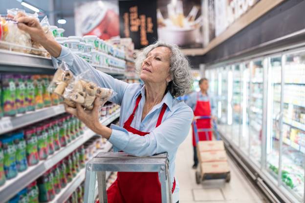 Older woman putting food on shelf - Age Discrimination